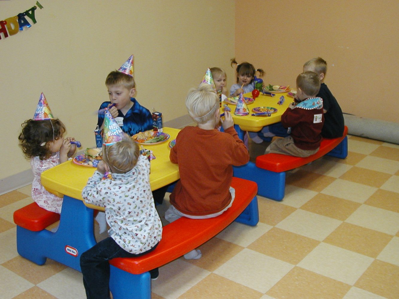Children gathered around a birthday cake at a party